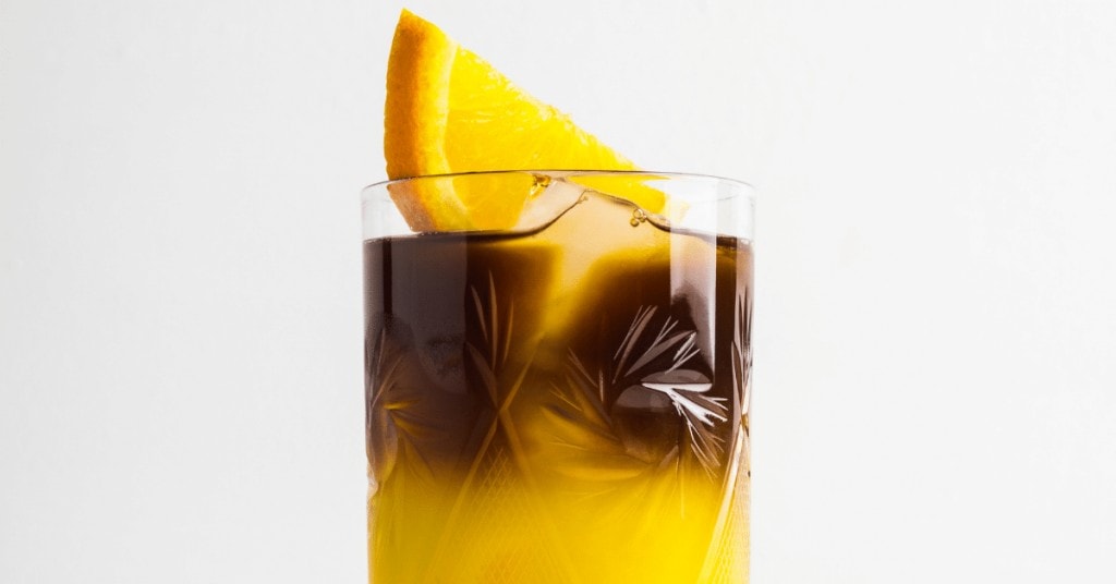 coffee and orange juice with a slice of orange on top