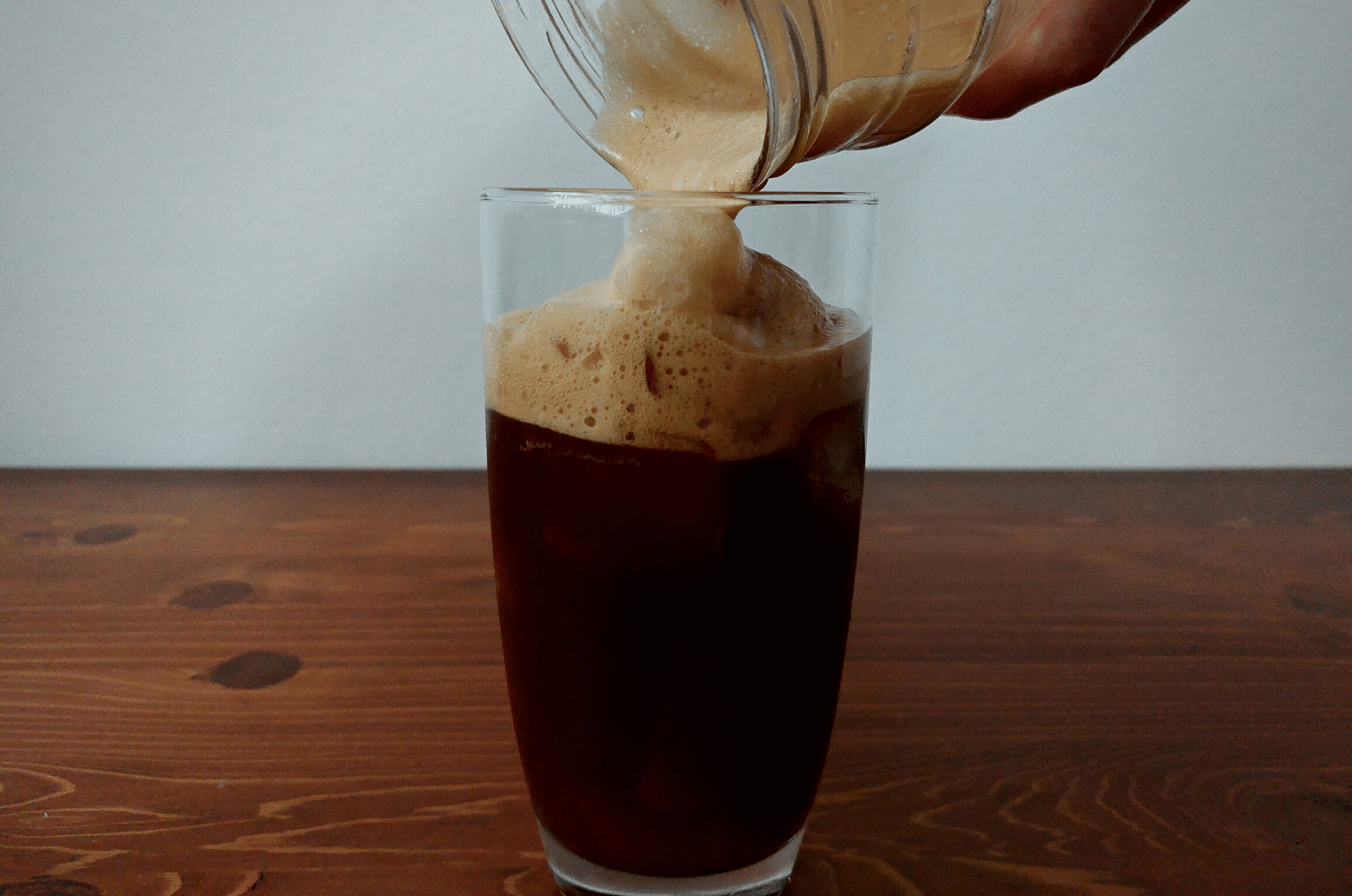 pouring shaken espresso in a glass