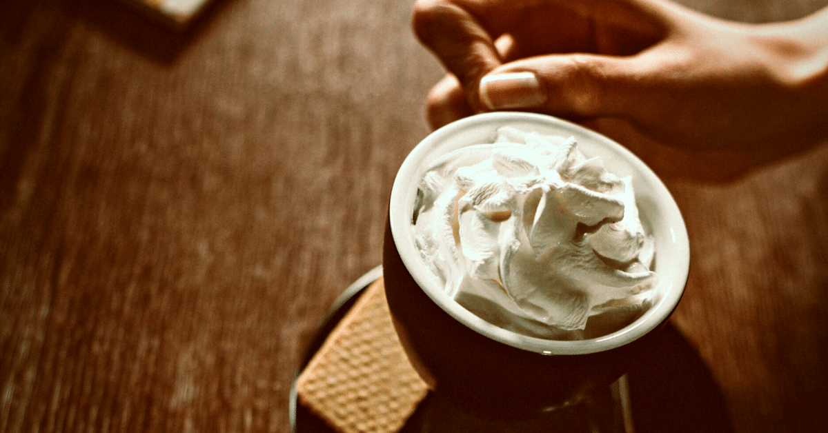 woman drinking coffee with whipped cream