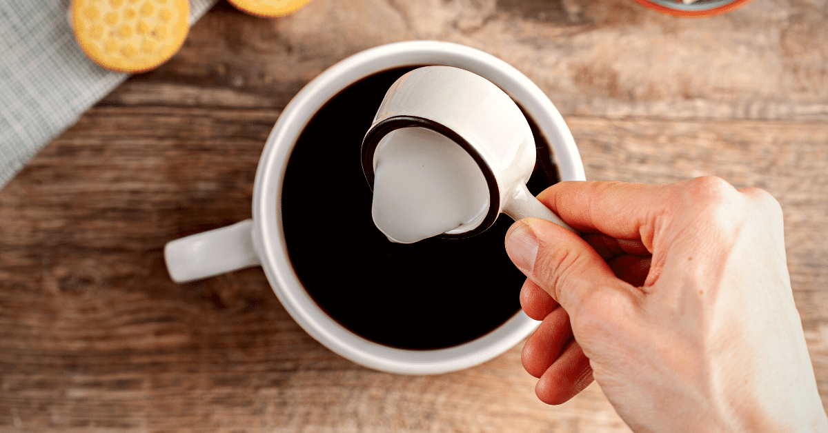 adding creamer into coffee