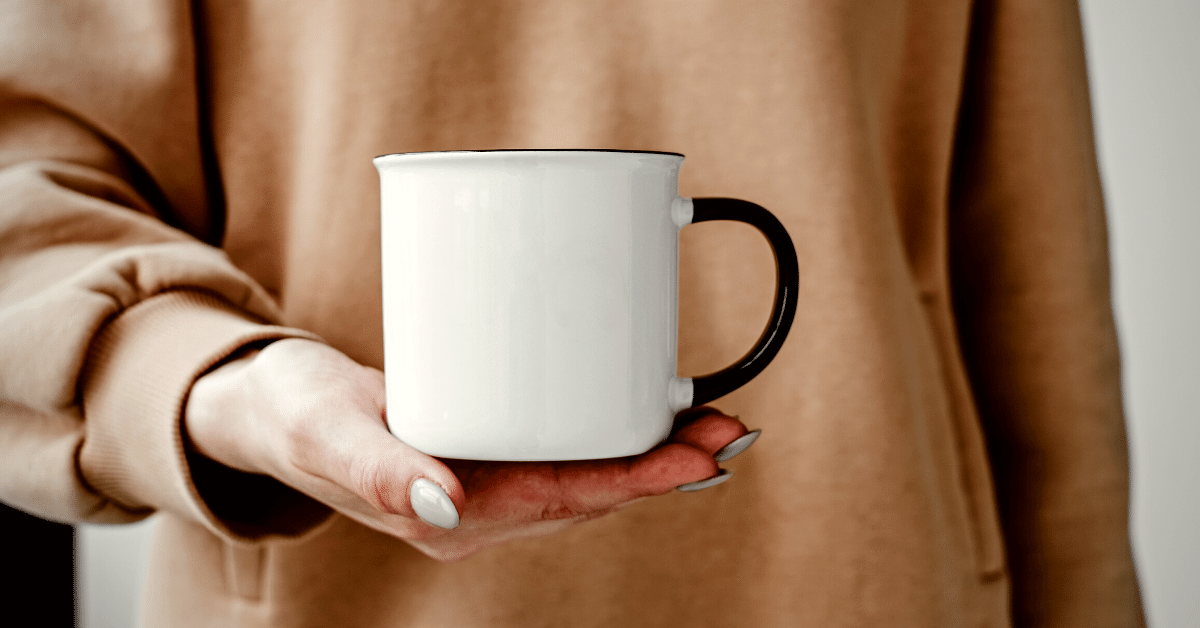 person holding ceramic mug