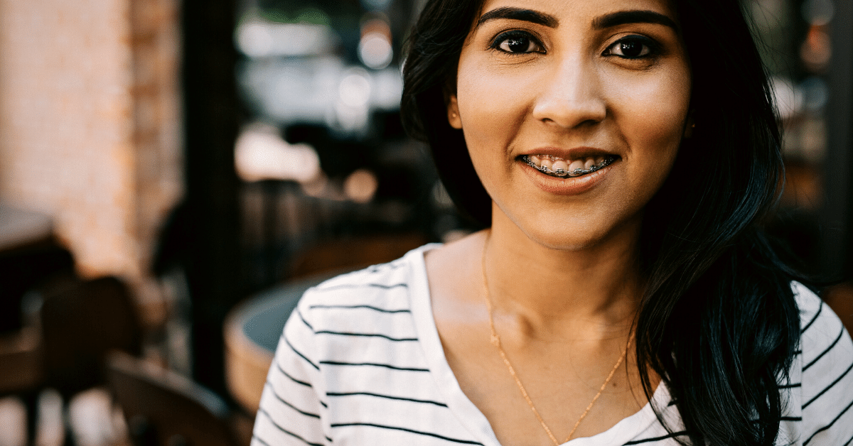 woman with braces sitting in a cafe