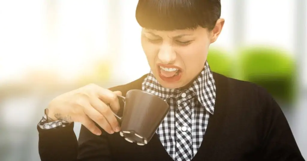 woman drinking bad coffee making grimace