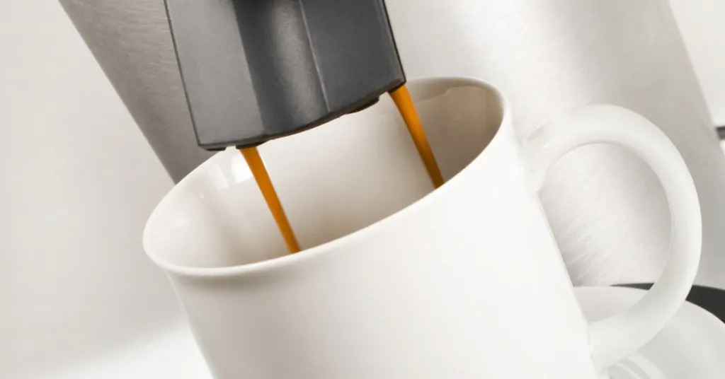 single serve coffee maker brewing coffee into a white mug