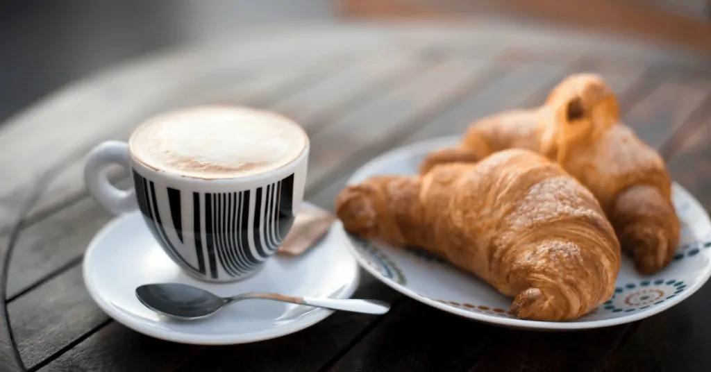 a cappuccino with two croissants