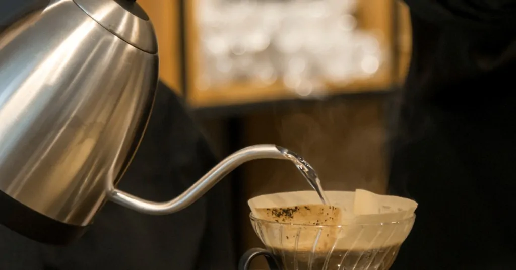 gooseneck kettle pouring water into a hario v60 dripper