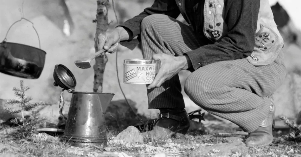 old black and white photo of a cowboy making coffee