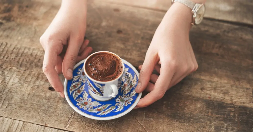 person serving a cup of turkish coffee