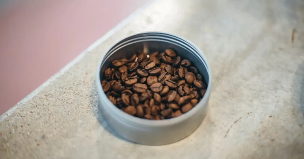 the lid of a coffee canister full of beans