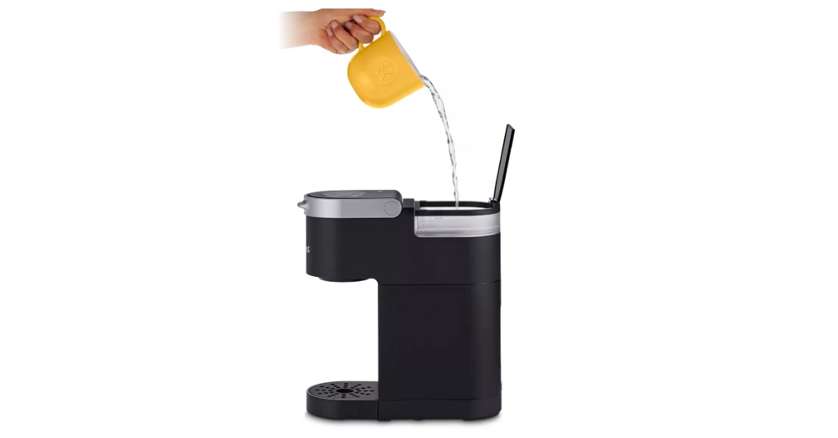a person pouring water in keurig mini