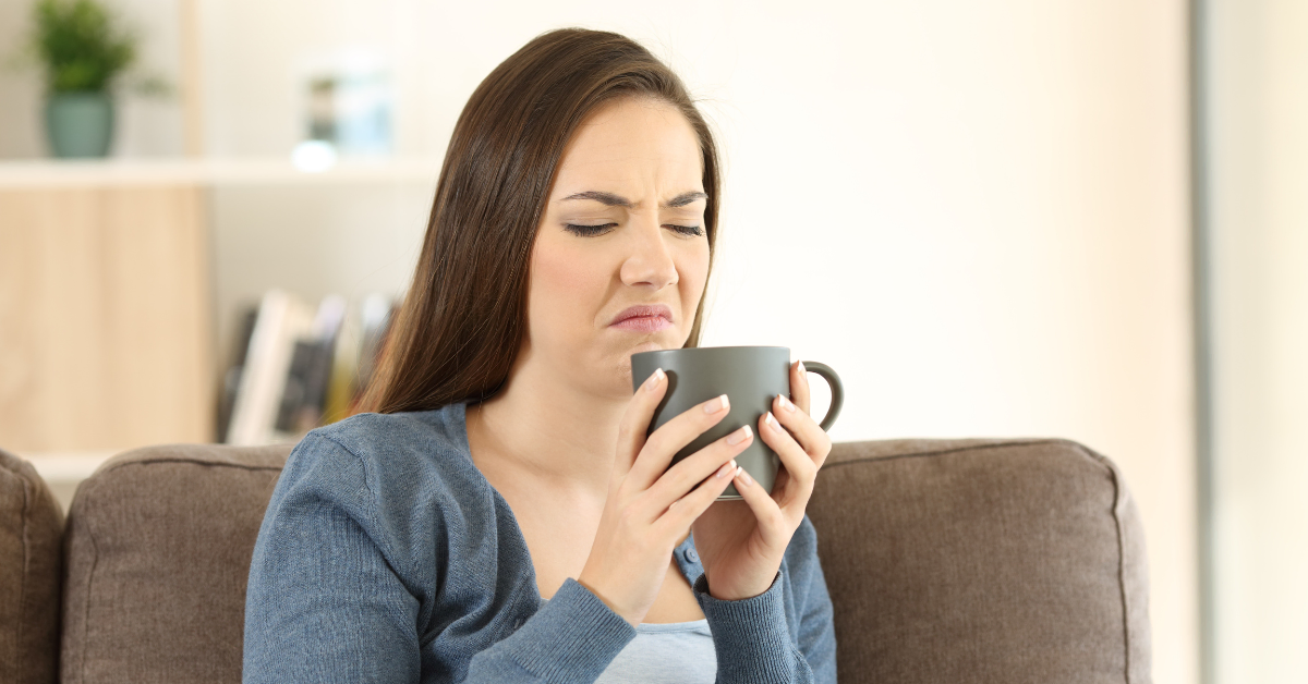 a woman holding smelly coffee.