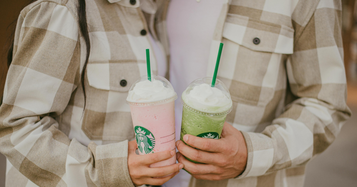 man and woman holding different starbucks drinks