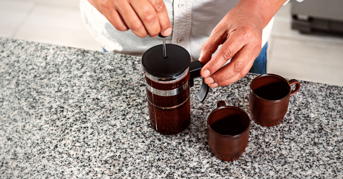 person preparing coffee with french press