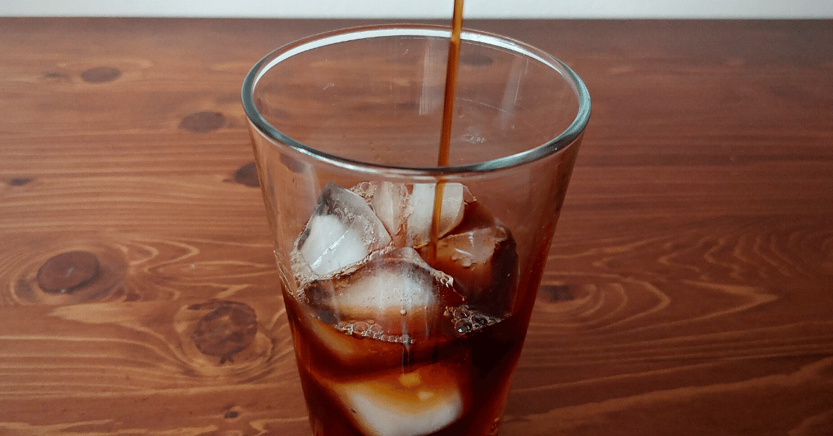 pouring cold brew on ice cubes