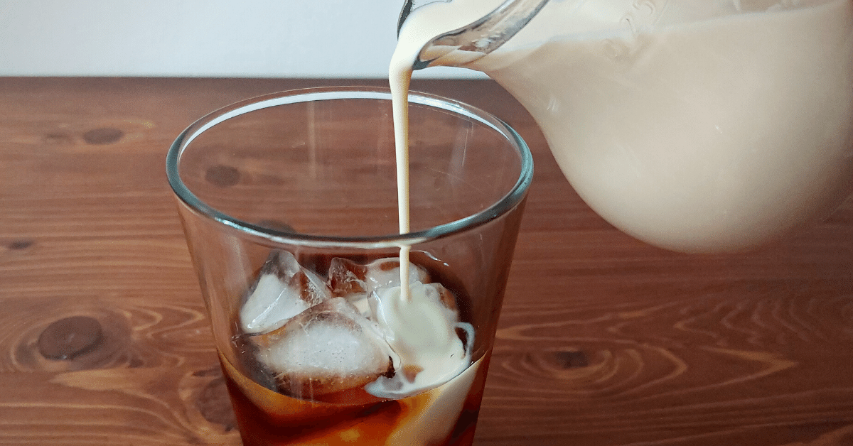 pouring milk in glass with cold brew