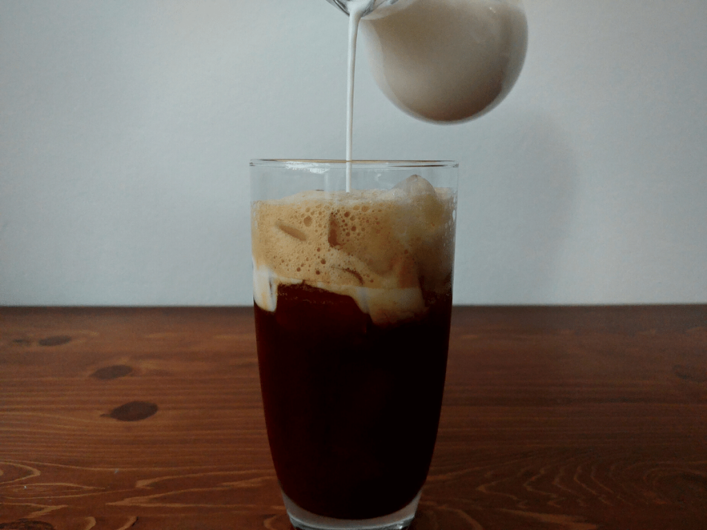 pouring milk in shaken espresso