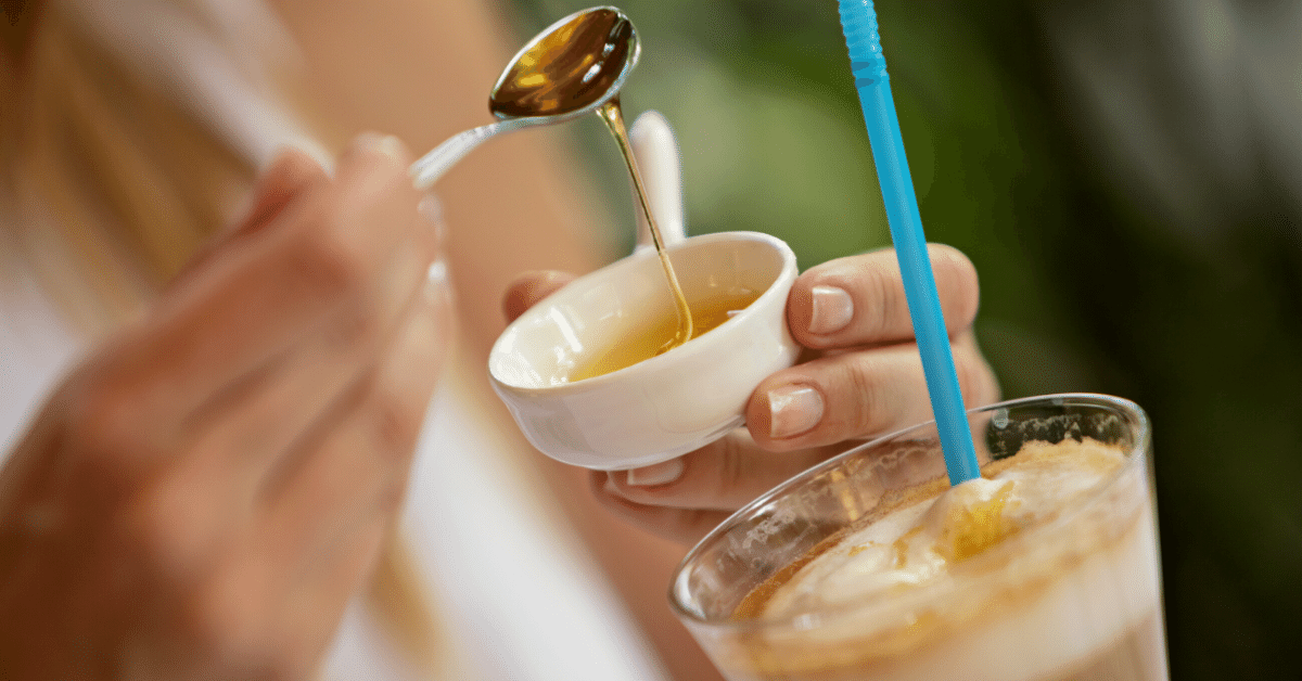 woman sweeting coffee with honey